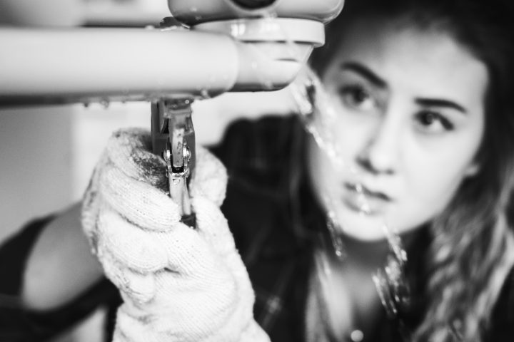 Woman fixing kitchen sink