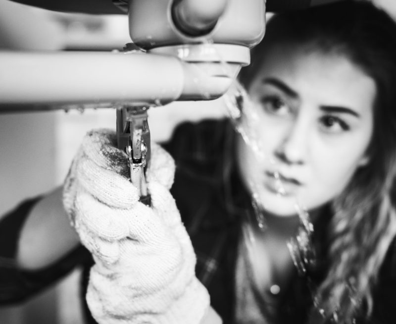 Woman fixing kitchen sink